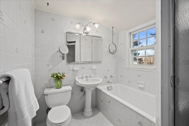 full bath with toilet, vaulted ceiling, tiled tub, and tile walls