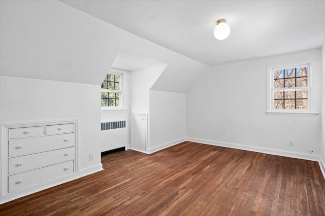 additional living space featuring radiator heating unit, vaulted ceiling, baseboards, and wood-type flooring