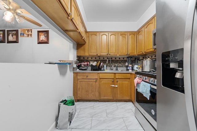 kitchen with decorative backsplash, ceiling fan, sink, and appliances with stainless steel finishes