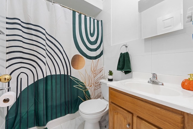 bathroom featuring vanity, tile walls, and toilet