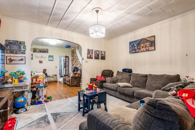 living room with crown molding, light hardwood / wood-style floors, and an inviting chandelier