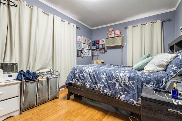 bedroom featuring hardwood / wood-style floors, ornamental molding, radiator, and a wall mounted AC