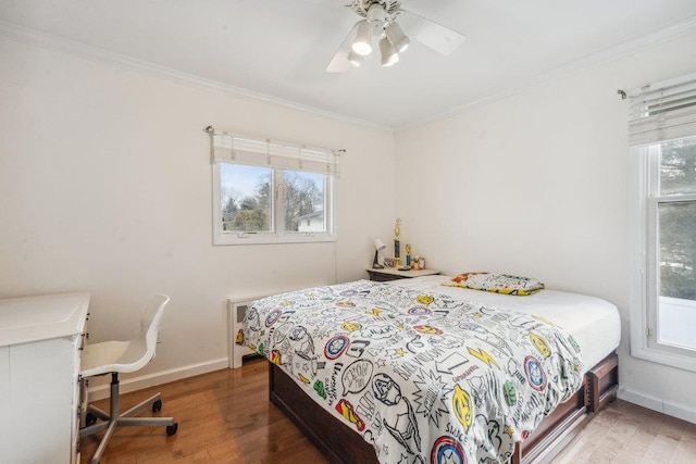 bedroom with ceiling fan, hardwood / wood-style floors, and ornamental molding