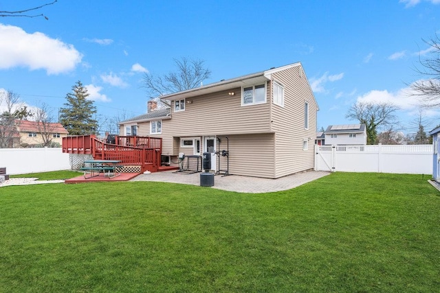 rear view of house featuring a yard, a patio area, and a wooden deck