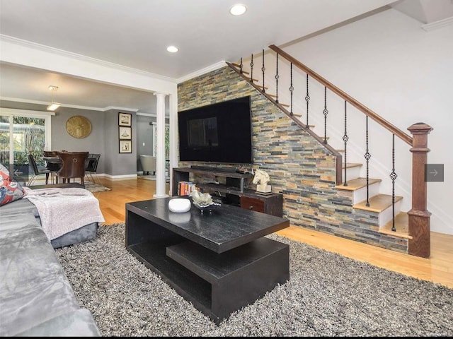 living room featuring hardwood / wood-style floors, ornate columns, and crown molding