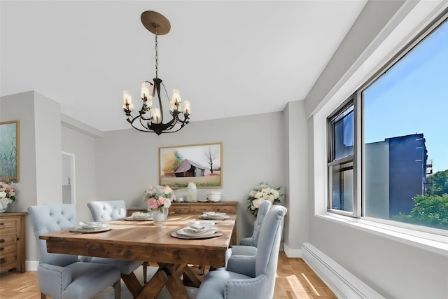 dining area with a notable chandelier, light parquet flooring, and a baseboard heating unit