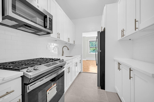 kitchen with appliances with stainless steel finishes, white cabinetry, and sink