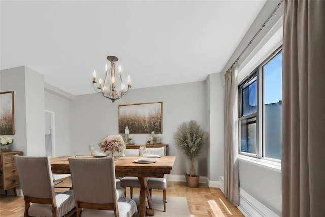 dining space with light parquet floors and a chandelier