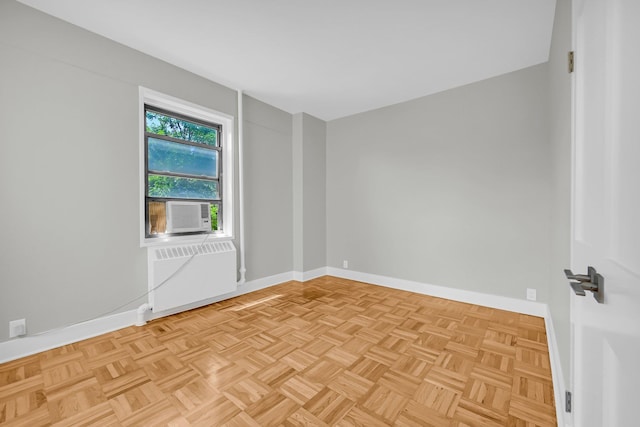 unfurnished room featuring radiator heating unit, cooling unit, and light parquet floors