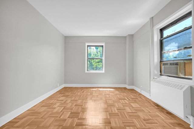 empty room with radiator and light parquet flooring