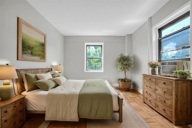 bedroom with cooling unit and light parquet flooring