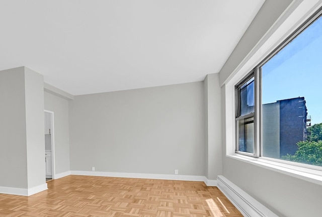 spare room with baseboard heating and light parquet flooring