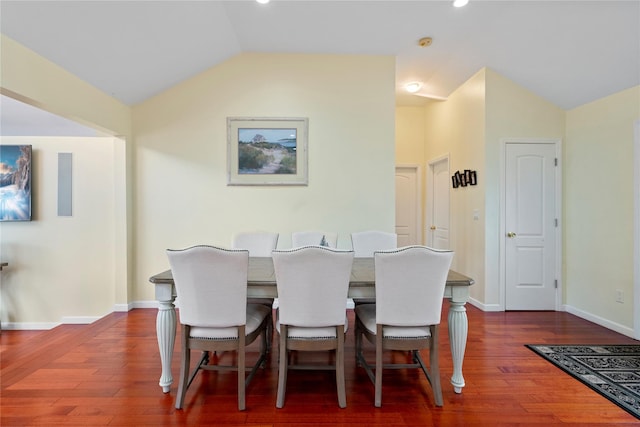 dining area featuring dark wood-type flooring and vaulted ceiling