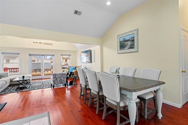 dining area featuring dark hardwood / wood-style flooring and vaulted ceiling