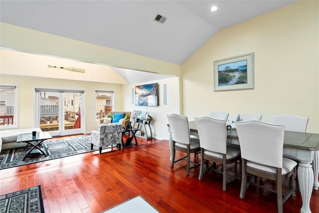 dining area featuring hardwood / wood-style floors and vaulted ceiling