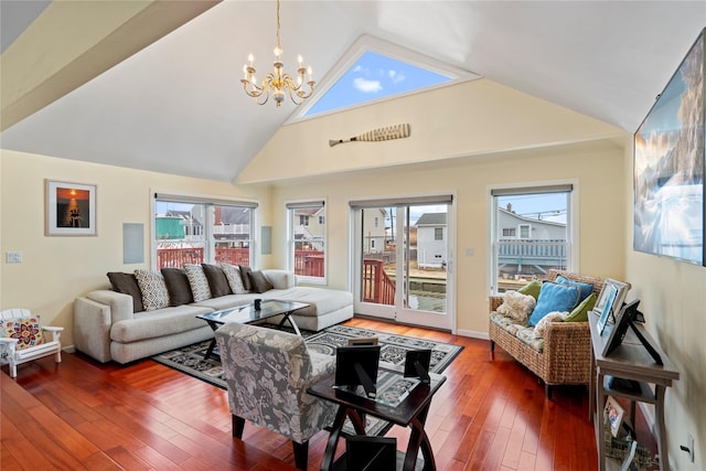 living room featuring high vaulted ceiling, a notable chandelier, and wood-type flooring