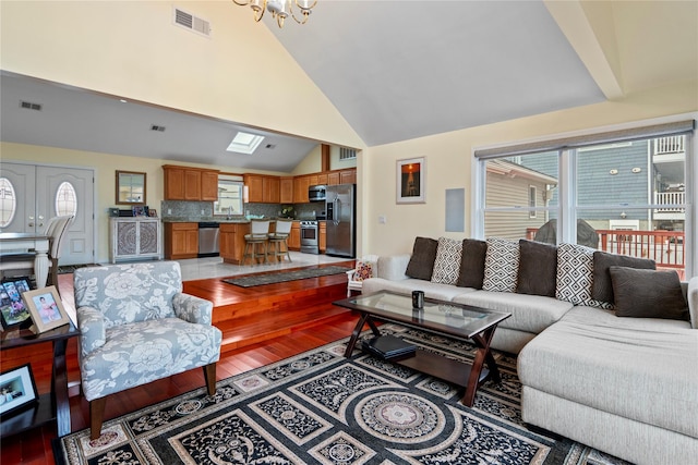 living room with sink, an inviting chandelier, lofted ceiling, and hardwood / wood-style flooring