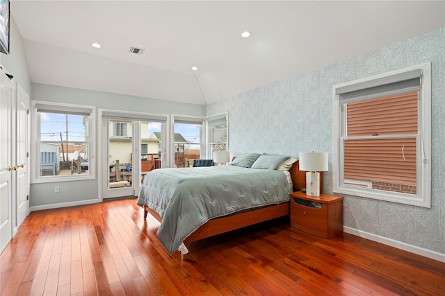 bedroom with access to outside, vaulted ceiling, and wood-type flooring