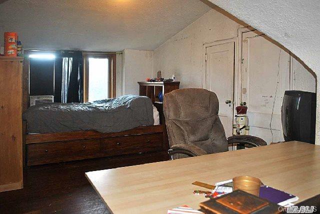 bedroom with hardwood / wood-style flooring and vaulted ceiling