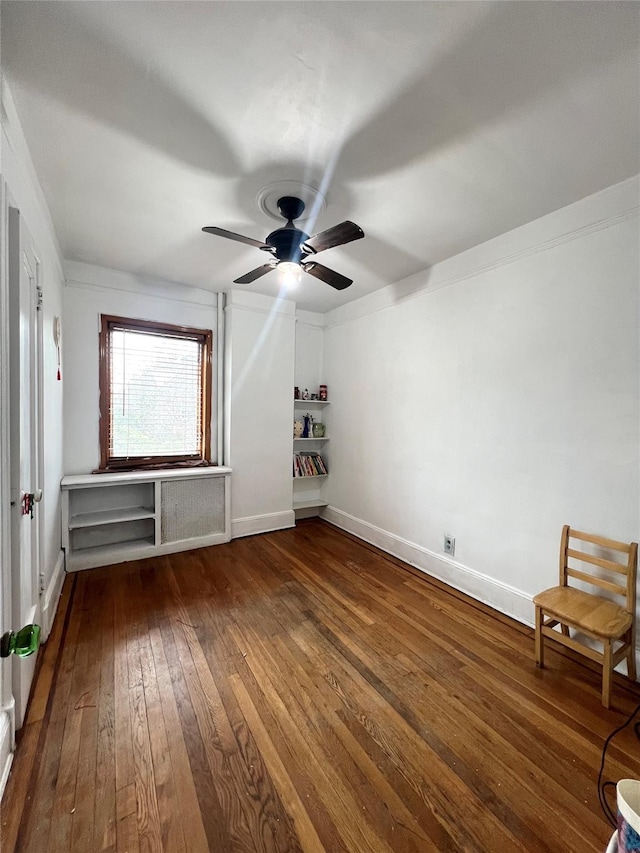 interior space with ceiling fan, dark wood-type flooring, and crown molding