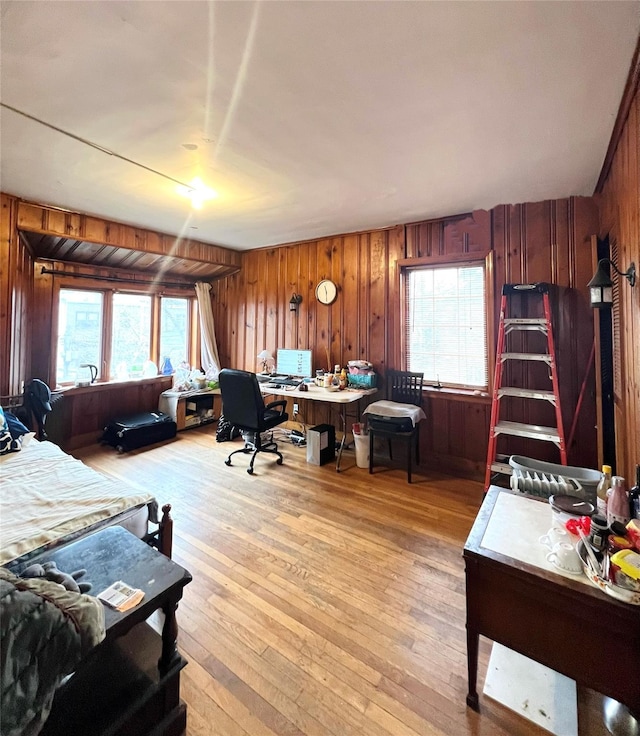 office with light hardwood / wood-style flooring and wood walls