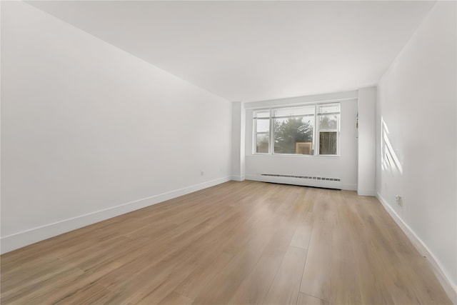 spare room featuring light hardwood / wood-style floors and a baseboard heating unit