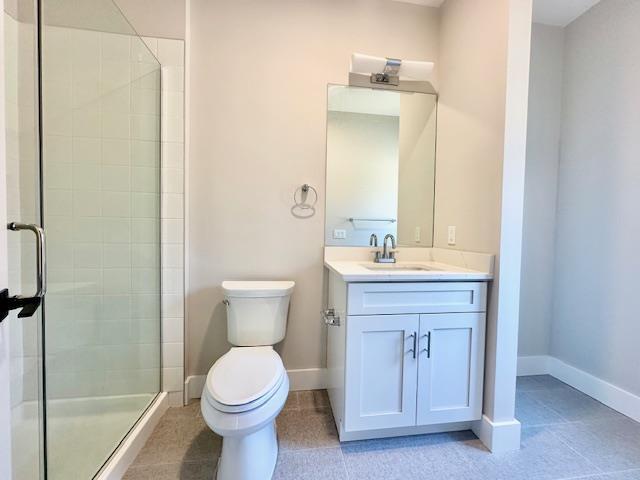 bathroom featuring vanity, toilet, and walk in shower