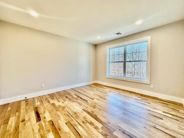 empty room with hardwood / wood-style flooring