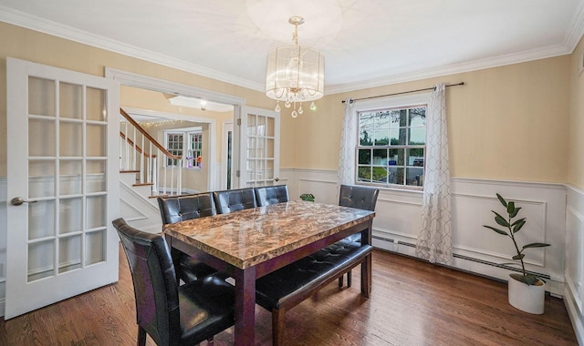 dining space featuring crown molding, french doors, dark wood-type flooring, and a chandelier