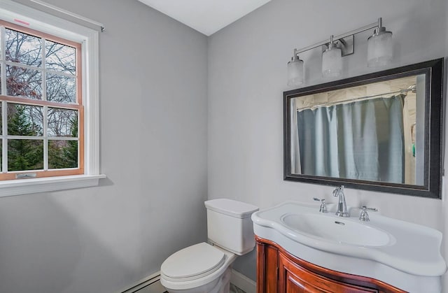 bathroom featuring baseboard heating, a shower with curtain, vanity, and toilet