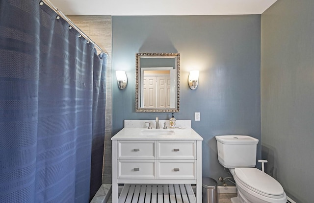 bathroom featuring toilet, vanity, and walk in shower