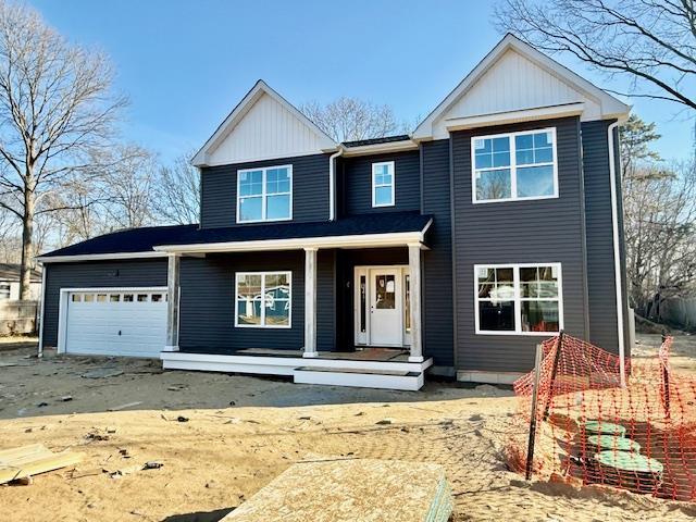 141 Crestwood Dr, Shirley, NY 11967 - view of front facade with a garage, a porch, and board and batten siding