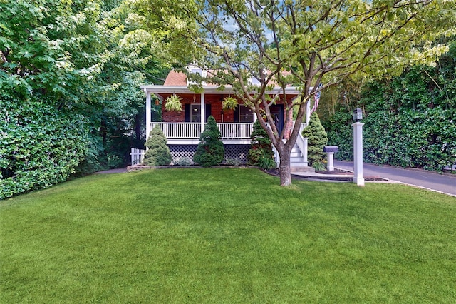 view of front of property featuring covered porch and a front yard