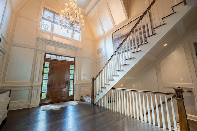 entrance foyer featuring a towering ceiling, plenty of natural light, and a notable chandelier