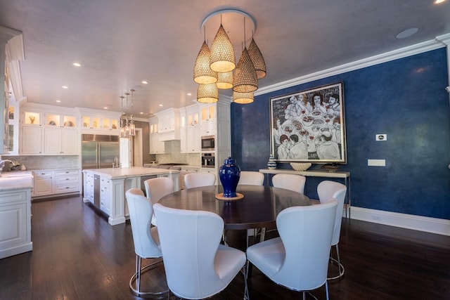 dining area featuring sink, dark hardwood / wood-style floors, and ornamental molding