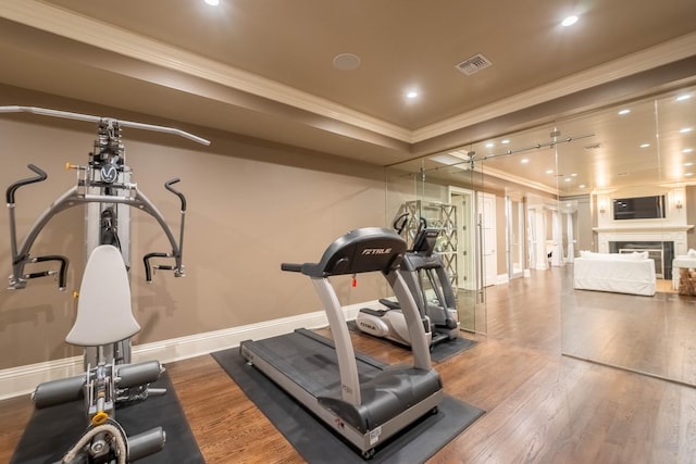 exercise area with crown molding and hardwood / wood-style flooring