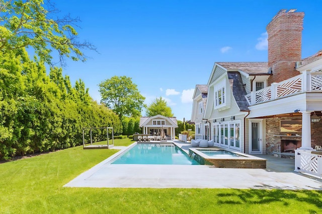 view of swimming pool with an in ground hot tub, a patio area, a yard, and an outdoor structure