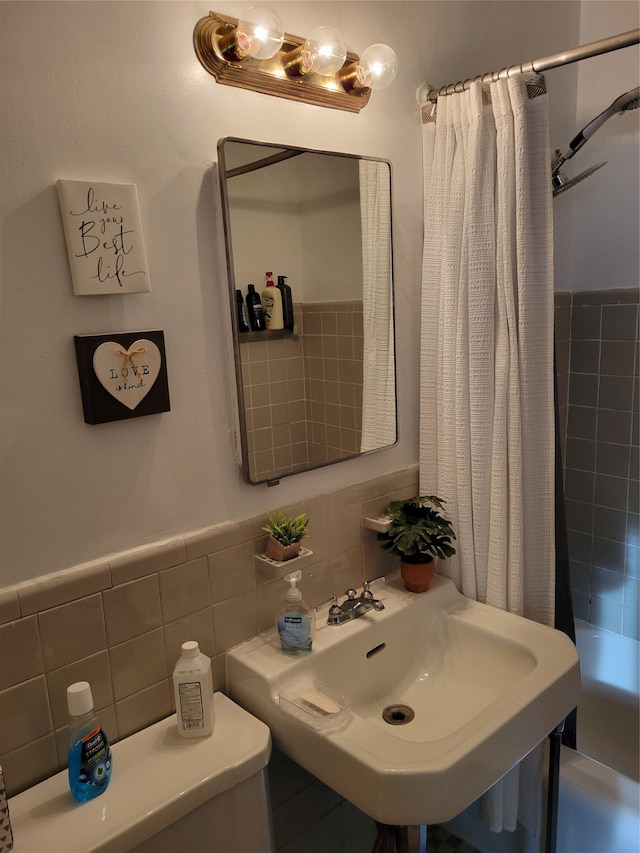 full bathroom featuring shower / bath combo, toilet, sink, and tile walls