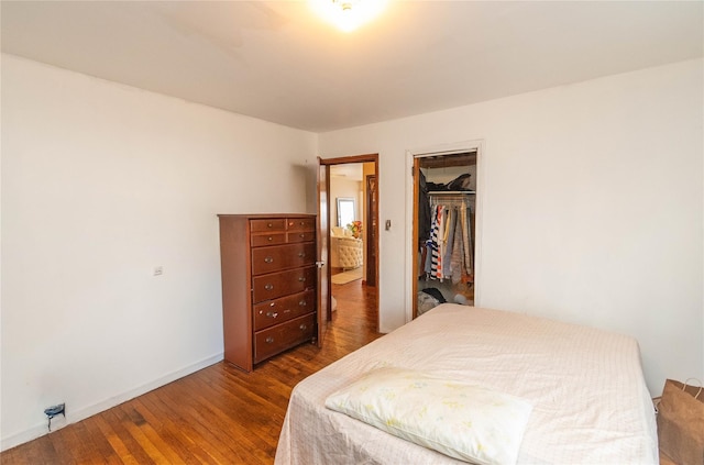 bedroom featuring dark hardwood / wood-style floors, a closet, and a walk in closet