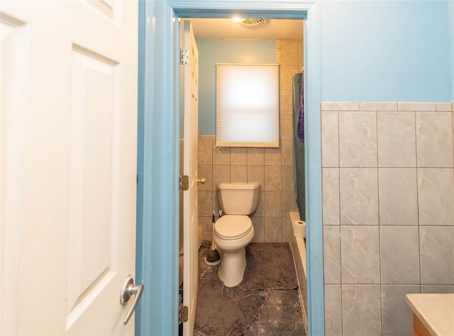 bathroom with toilet, tile walls, and vanity