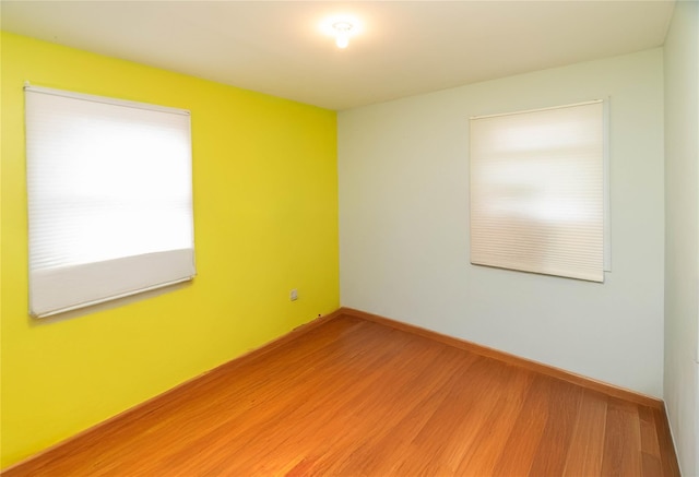 unfurnished room with hardwood / wood-style flooring