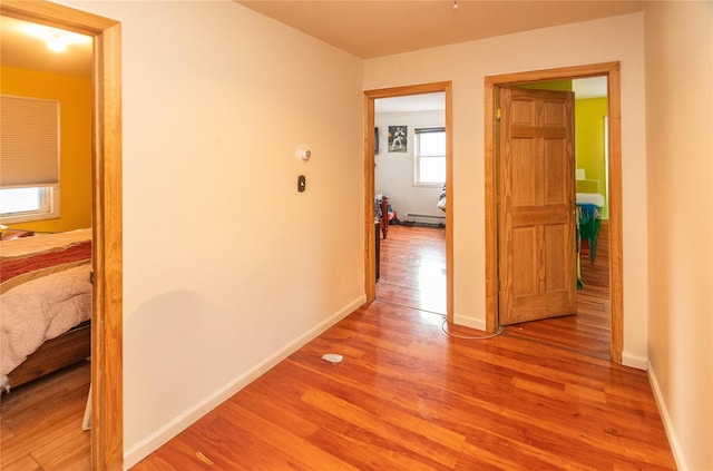 hallway featuring a baseboard heating unit and light hardwood / wood-style floors