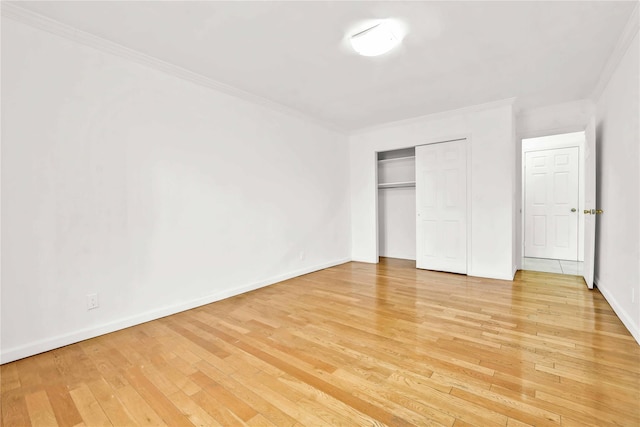 unfurnished bedroom featuring wood-type flooring, a closet, and crown molding