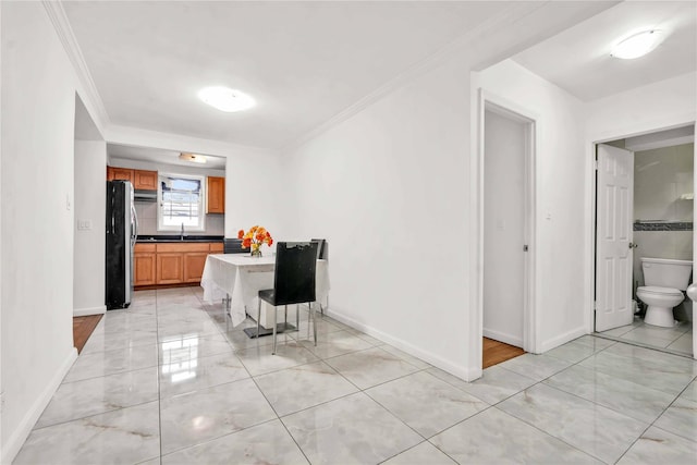 dining room featuring sink and crown molding