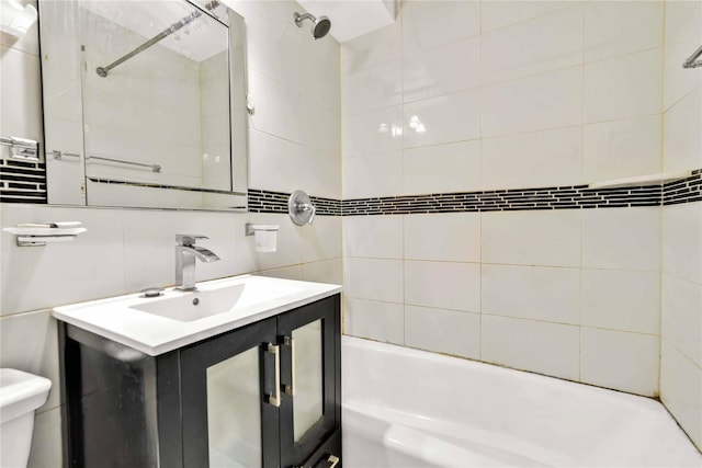 full bathroom with tiled shower / bath combo, toilet, vanity, tile walls, and decorative backsplash