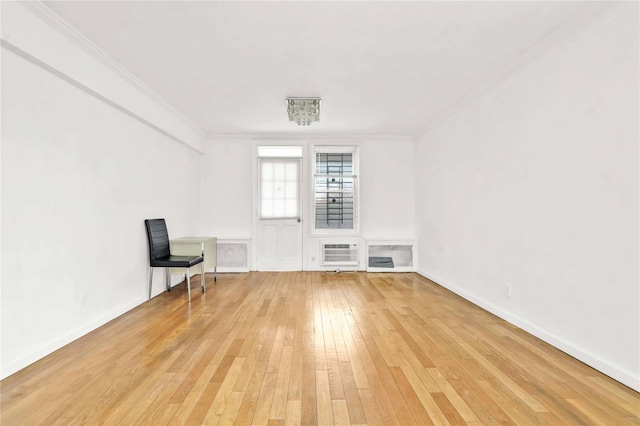 unfurnished room featuring a notable chandelier, crown molding, and light hardwood / wood-style flooring