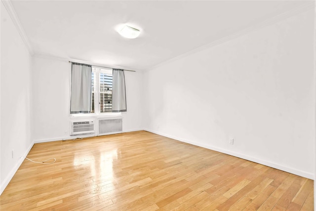 spare room with light wood-type flooring, crown molding, and a wall mounted AC