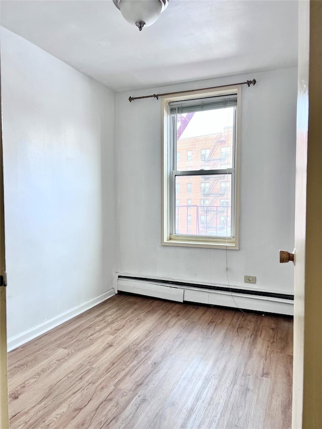 spare room featuring light hardwood / wood-style flooring and baseboard heating