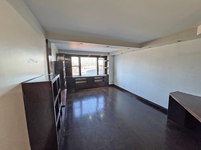 unfurnished living room with dark wood-type flooring