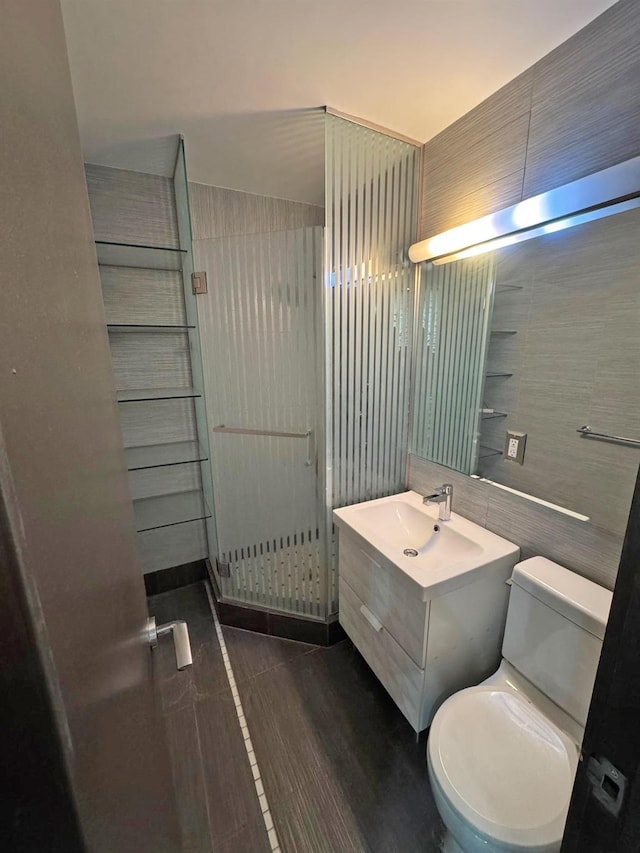 bathroom with vanity, toilet, and tile walls